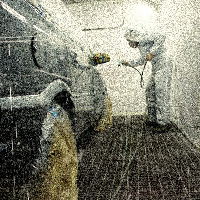 Mecanico pintando coche con spray